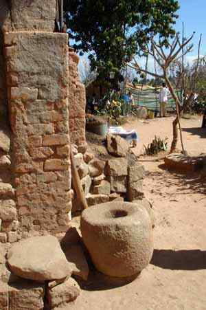 Ambohitriniarivo les pierres creuses au premier plan: le traditionnel loana pour piler le riz, le manioc