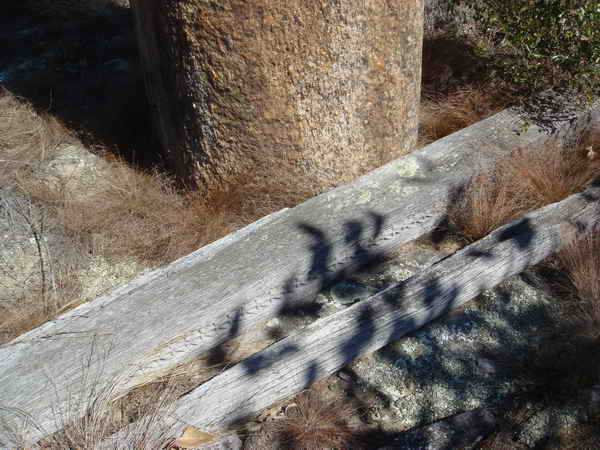 sa base est entourée d'une bordure de pierres enfoncées dans le sol, «mais il est muni d'une garniture de bois, portée par deux poteaux